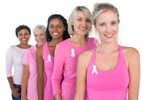 Smiling,Women,Wearing,Pink,And,Ribbons,For,Breast,Cancer,On